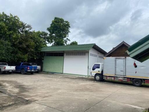 Spacious exterior parking area with garage and storage buildings