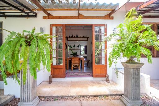Inviting entrance of a home with open doors and lush greenery