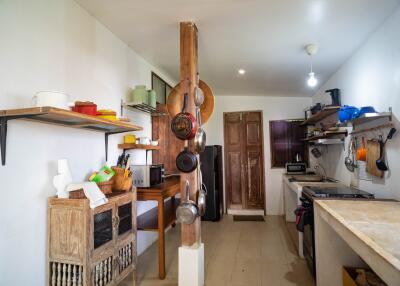 Spacious and well-lit kitchen with rustic wooden furnishings and white walls