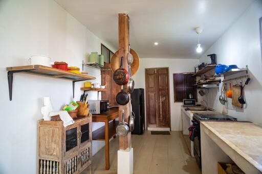 Spacious and well-lit kitchen with rustic wooden furnishings and white walls