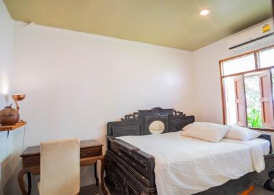 Spacious and well-lit bedroom with traditional wooden furniture