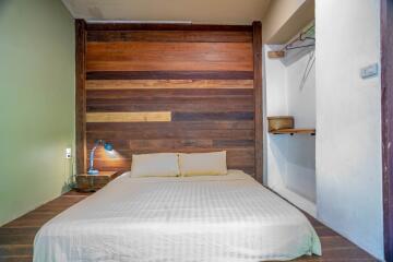 Cozy bedroom with multi-toned wooden wall and minimalist decor