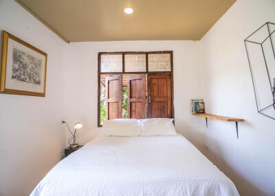Cozy bedroom with natural light and rustic wooden door