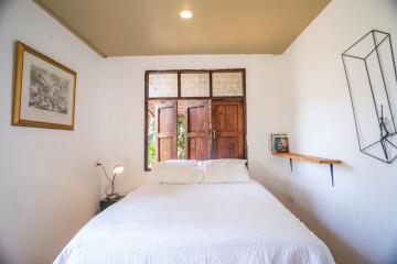 Cozy bedroom with natural light and rustic wooden door