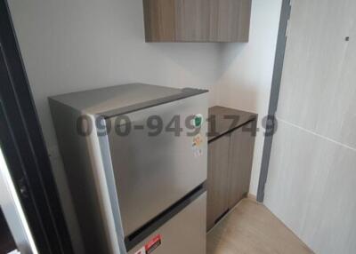 Compact kitchen corner with modern refrigerator and wooden cabinets