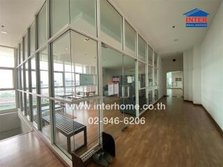 Spacious office space with large windows and glass partition walls
