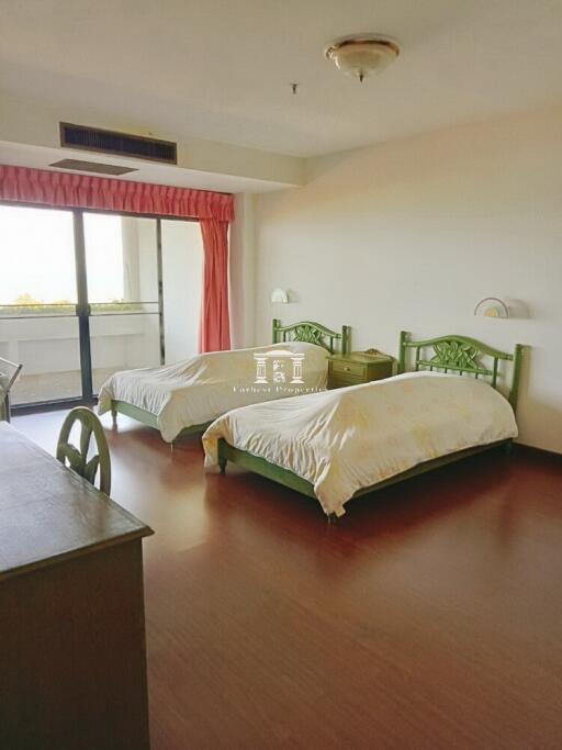 Spacious bedroom with two beds and ample natural light