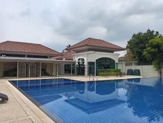 Luxurious poolside view of a residential property with a spacious outdoor area