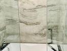 Luxurious marble tiled bathroom with bathtab and glass shower