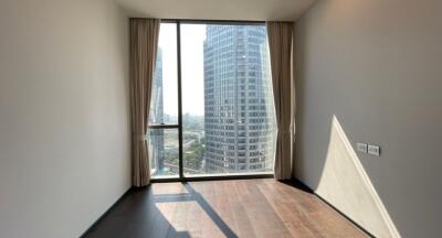 Spacious bedroom with large window overlooking the city