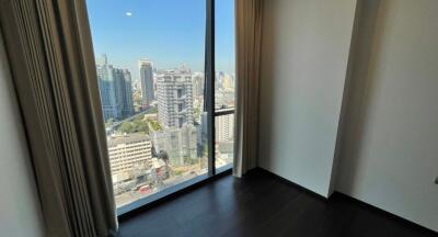 Modern bedroom with large window overlooking cityscape