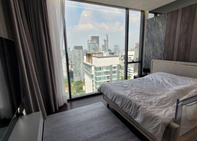 Modern bedroom with large window overlooking the city skyline