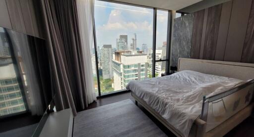 Modern bedroom with large window overlooking the city skyline