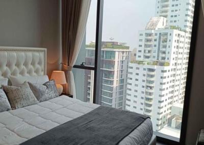 Elegant bedroom with a large window providing a cityscape view