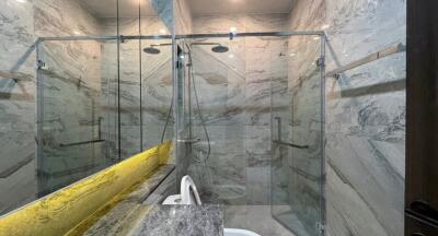 Modern bathroom with glass shower enclosure and marble tiles