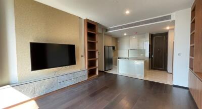 Spacious living room with integrated kitchen, wooden flooring, and modern design