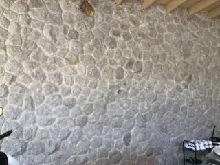 Close-up of a textured stone wall, possibly in an outdoor area