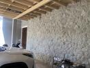 Stone wall garage interior with visible vehicles and wooden ceiling beams