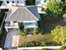 Aerial view of a modern single-family home with a large garden and driveway