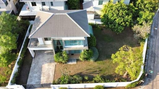 Aerial view of a modern single-family home with a large garden and driveway