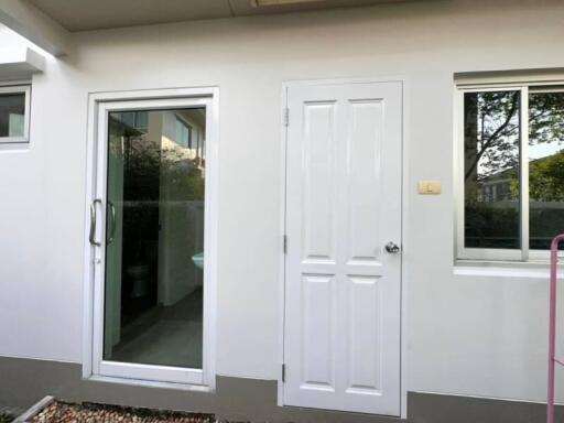 Modern home exterior with glass door and white entrance door