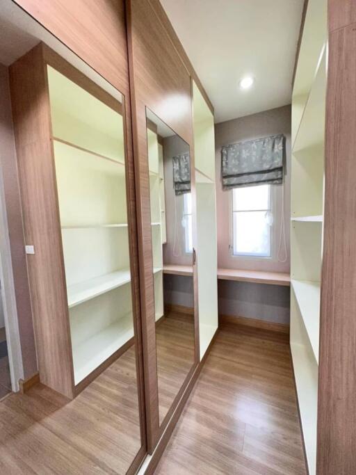 Spacious bedroom with large mirrored wardrobe and wooden flooring