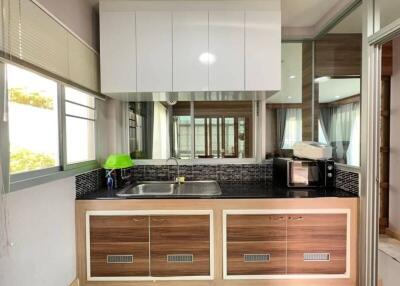 Modern kitchen with wooden cabinets and black tile backsplash