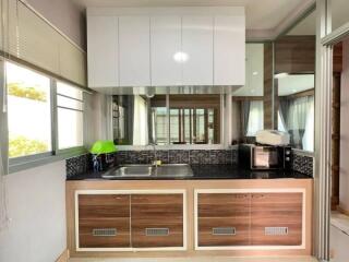 Modern kitchen with wooden cabinets and black tile backsplash