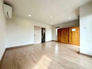 Spacious and well-lit living room with wooden flooring