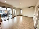 Spacious and well-lit living room with large windows and balcony access