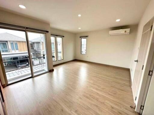 Spacious and well-lit living room with large windows and balcony access