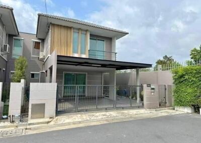 Contemporary two-story house with a secure gate and landscaped exterior