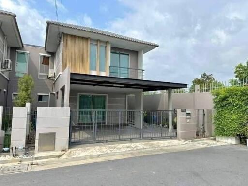 Contemporary two-story house with a secure gate and landscaped exterior