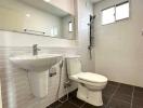 Modern bathroom with white fixtures and dark tiled floor