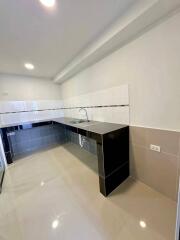 Modern kitchen with white tiled walls and a dark countertop