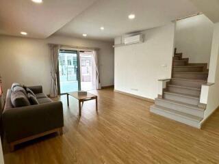 Spacious living room with modern furniture and staircase