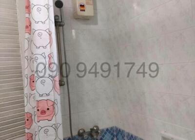 Compact bathroom with a playful animal-themed shower curtain and tiled walls