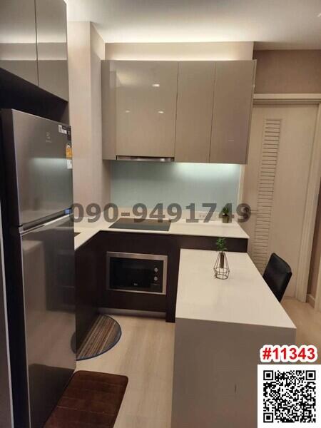 Modern compact kitchen with integrated appliances and warm lighting