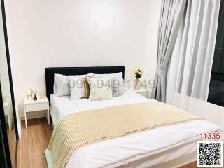 Modern bedroom with a large bed, white and gold bedding, and minimalistic decor