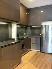 Modern kitchen with wooden flooring and dark cabinets