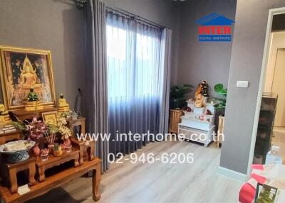 Spacious and well-decorated living room with religious shrine and modern amenities