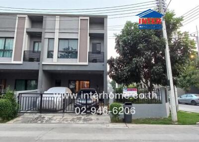 Exterior view of modern townhouses with company signage and contact information