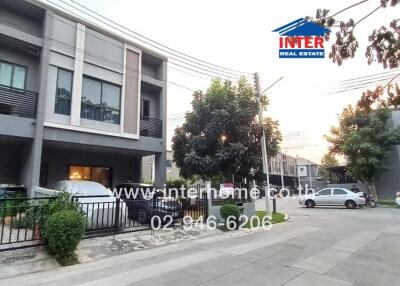 Modern residential building exterior with parking and twilight ambiance
