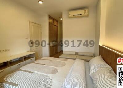 Modern bedroom interior with twin beds, air conditioning, and built-in storage