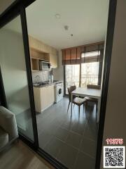 Compact kitchen and dining area with modern appliances and glass door leading to the living room