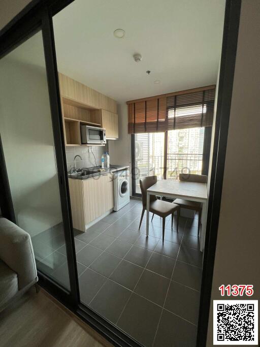 Compact kitchen and dining area with modern appliances and glass door leading to the living room