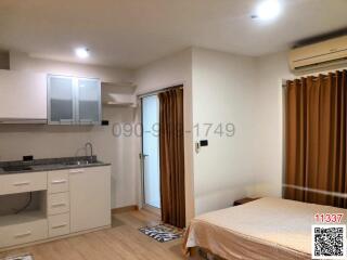 Compact studio apartment interior with integrated kitchen and sleeping area