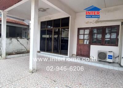 Outdoor view of a building with tiled flooring and a small air conditioning unit