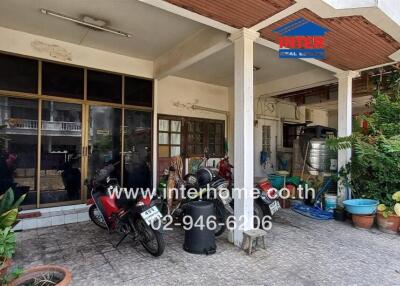 exterior view of a residential building with motorcycles and potted plants