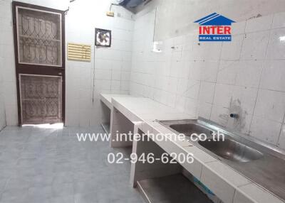 Basic kitchen with tile countertops and stainless steel sink